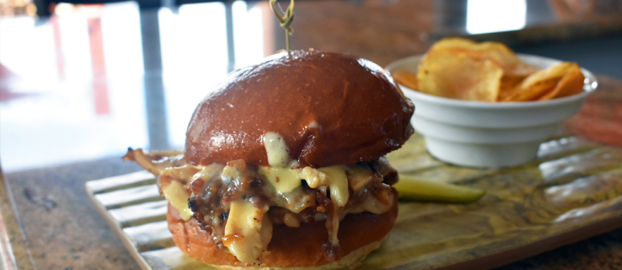 Grilled chicken sandwich on a brioche bun with house chips
